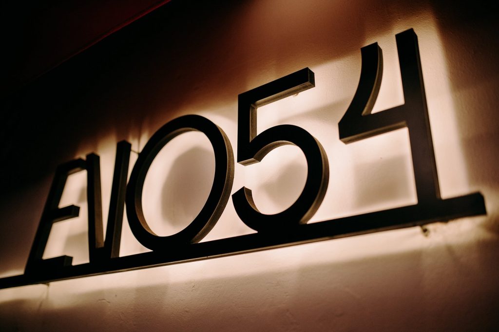 Modern LED backlit metal address sign on a building wall