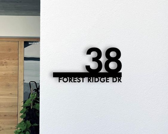 Backlit house number sign installed beside an entrance