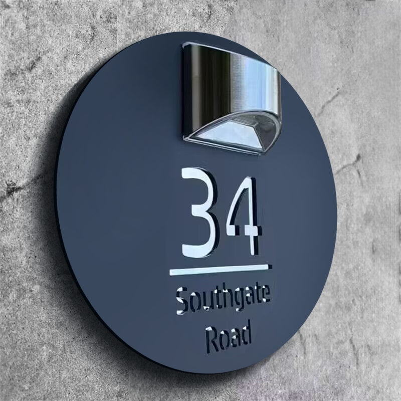 Round solar house plate with built-in solar panel glowing at dusk