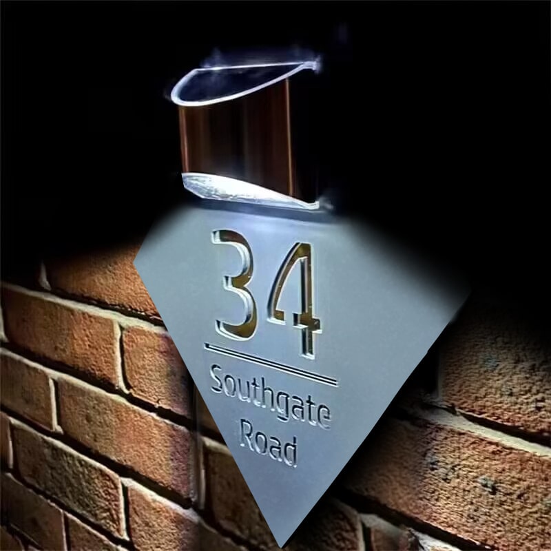 Diamond solar house plate glowing at night on a home exterior