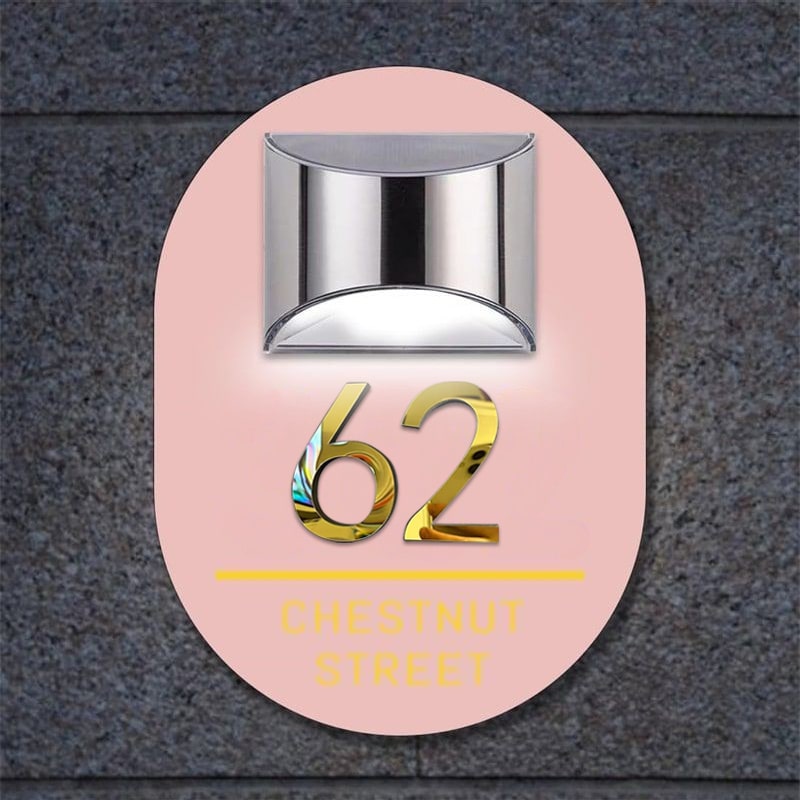 Oval solar 3D house sign glowing at night